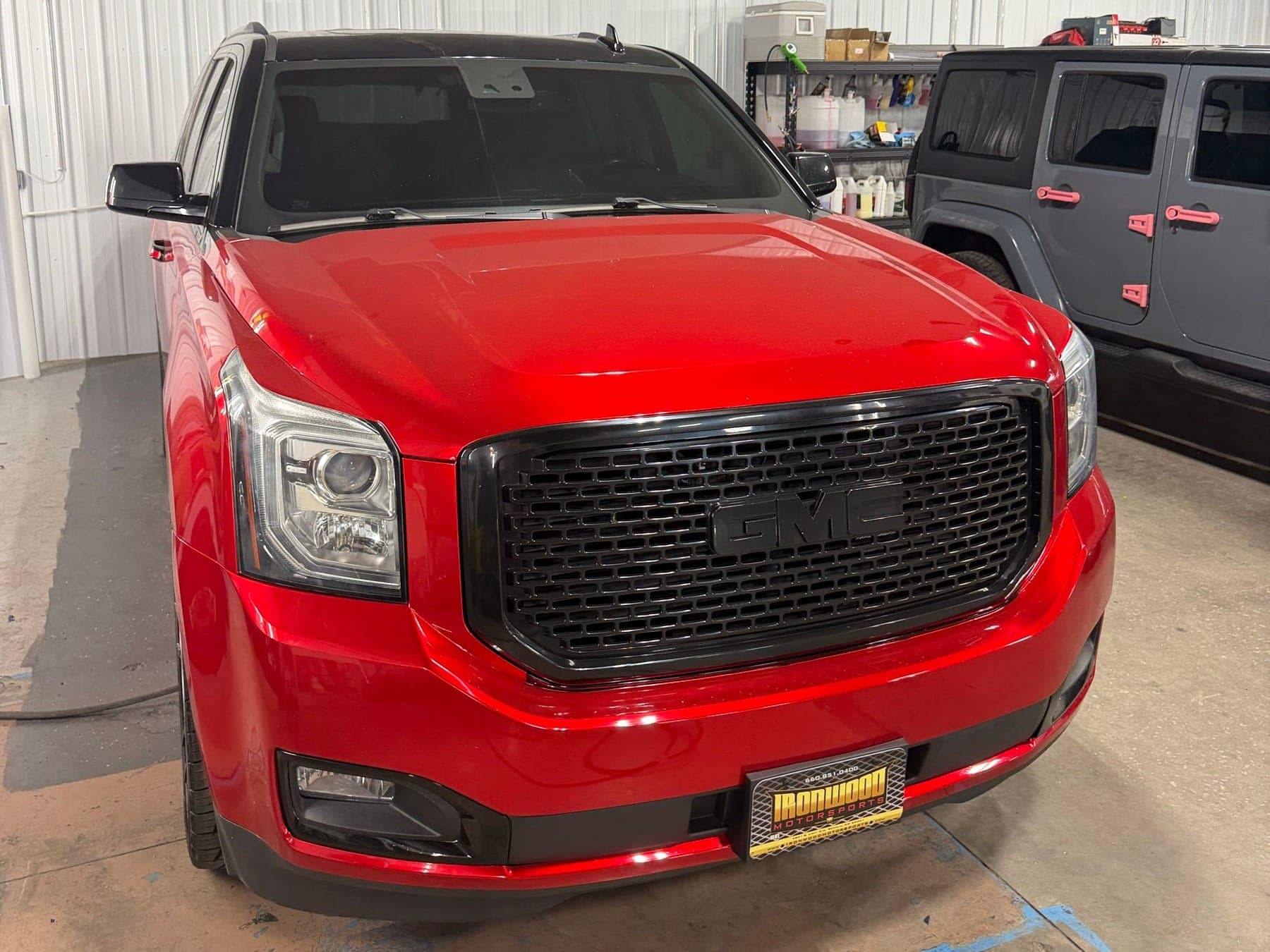 Red GMC SUV parked in the Ironwood Motorsports indoor work bay